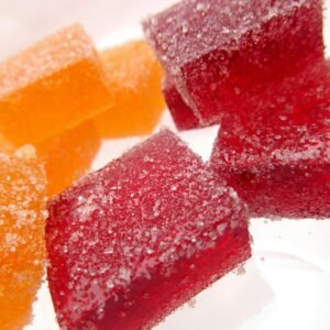Bright and vibrant sugar-coated red and orange jelly candies in a close-up macro shot.